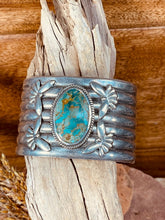 Load image into Gallery viewer, Navajo Cuff Bracelet with a large center Turquoise stone and 4 Birds appliqued on it.  The stone measures 1 1/4&quot; x 3/4&quot; and is surrounded by twisted wire.  It also features 4 birds in flight, 2 on each side of the stone.  This piece is very unique as the band is stamped into 7 sections encircling your wrist.
